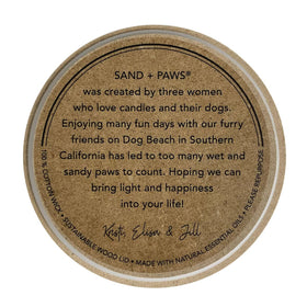 Decorative jar top of Sand + Paws Ocean Mist candle with artwork.