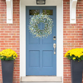 Sggvecsy Blue Daisy Wreath shows lush green foliage and clustered flowers.