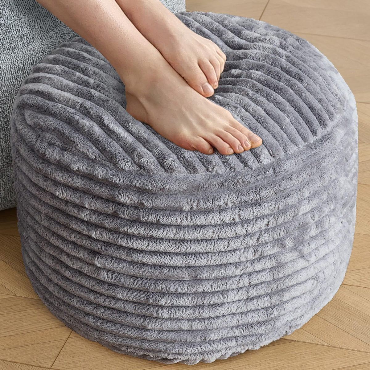 SHOUREN corduroy round ottoman in dark grey used as a footrest with storage