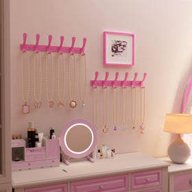 SKOLOO pink wall hook rail demonstrates space-saving, multipurpose storage for coats and bags.
