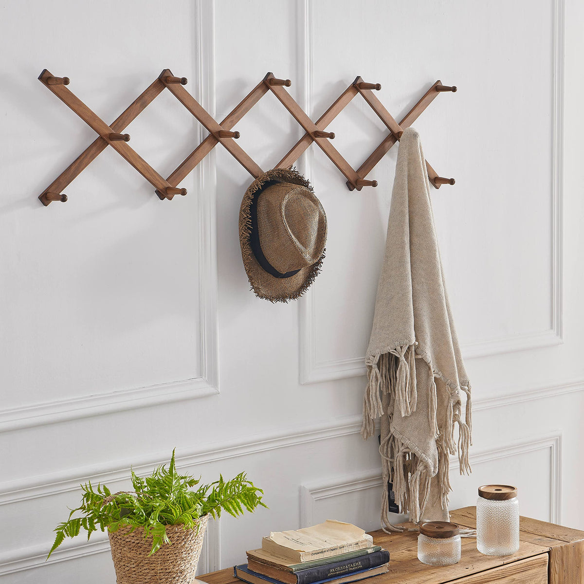 Close-up of SKOLOO expandable wall hanger showing accordion mechanism for flexible space.