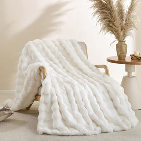 Smoofy faux fur throw with cream bubble texture on a neutral sofa.