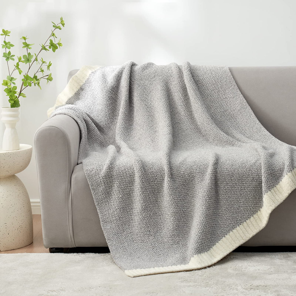 Snuggle Sac Buttery Grey blanket folded on bed adds plush texture for cozy mornings