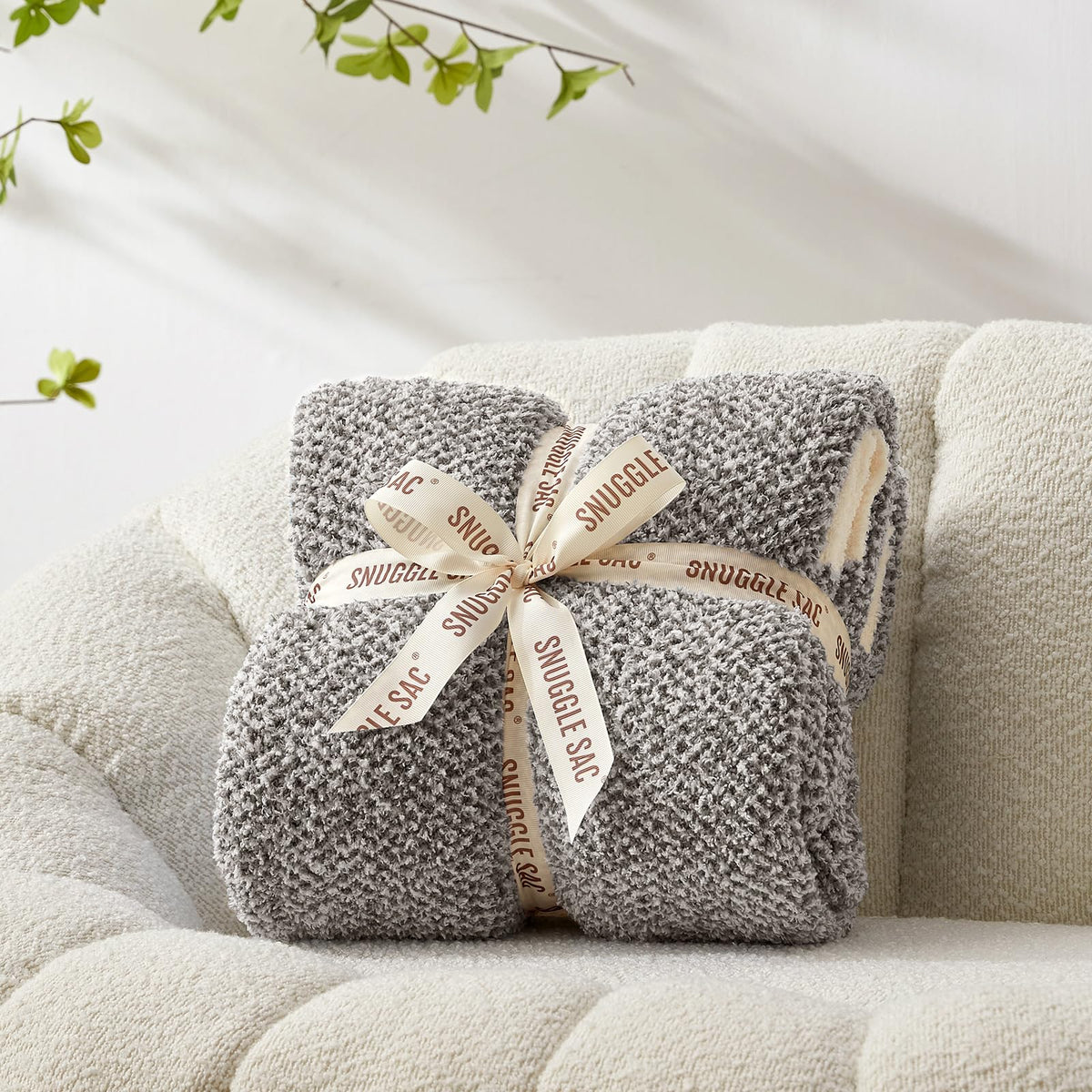 Snuggle Sac cozy throw draped over bed demonstrates decorative warmth.