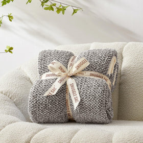 Snuggle Sac cozy throw draped over bed demonstrates decorative warmth.