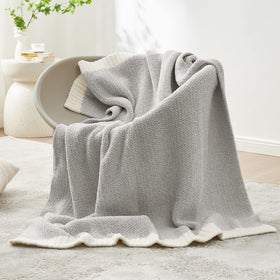 Snuggle Sac Heather Grey Throw folded on sofa for welcoming decor and warmth.