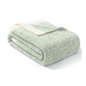 Sage green throw draped on bed adds warmth and texture to the room