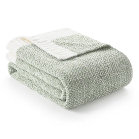 Snuggle Sac sage green throw blanket on couch for cozy evenings.