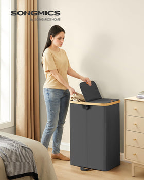 SONGMICS two-compartment basket with light and dark labels simplifies sorting during laundry.
