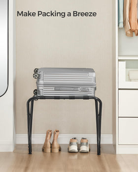 SONGMICS black steel-framed luggage rack in a modern bedroom