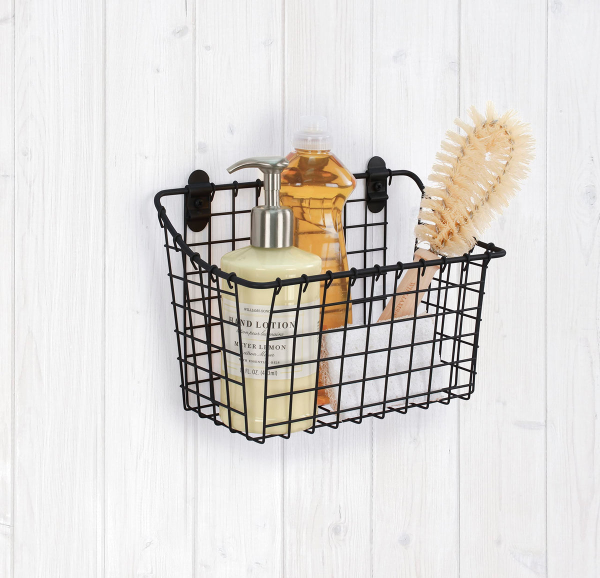 Spectrum wall-mounted wire basket in bathroom scene for easy access to toiletries.