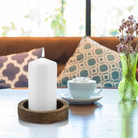 Stonebriar pillar candle glows warmly on the fireplace mantel.