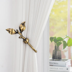 SUQ I OME bronze finish curtain holders blend with blinds and drapes.