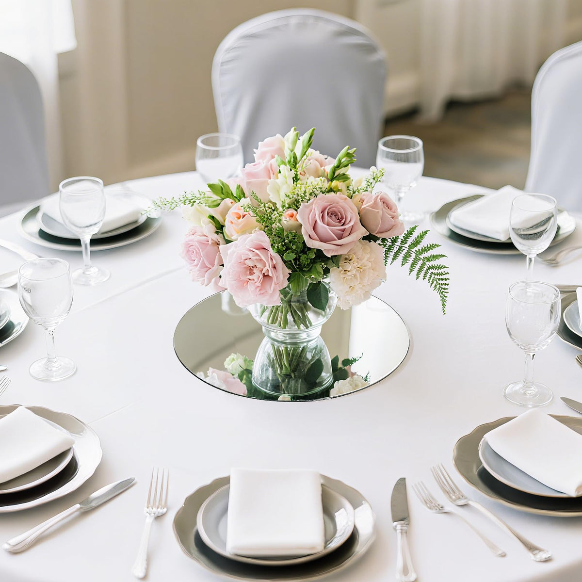 Suwimut candle and flower display using mirror tray creates luminous centerpieces.