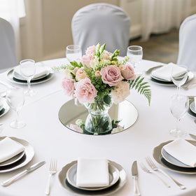 Suwimut candle and flower display using mirror tray creates luminous centerpieces.