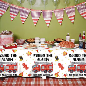 Suzkoqo firetruck tablecloth ties the theme together while protecting surfaces.