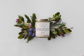Sweet Water Decor Engaged Era Candle lid adds a touch of elegance to the display.