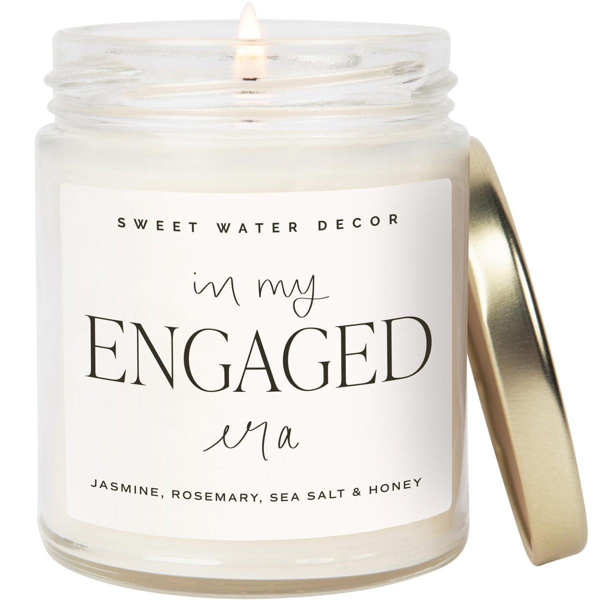 Sweet Water Decor Engaged Era Candle jar enhances cozy decor with warm glow.