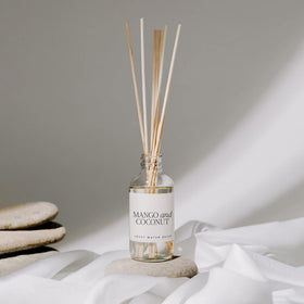 Sweet Water Decor mango-orange diffuser bottle on a coffee table for everyday freshness.