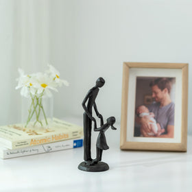 Sziqiqi black-matte iron sculpture showcasing a tender father-daughter bond.