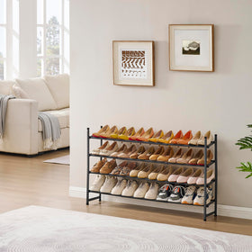 Tajsoon black finish shoe rack beside shoes for neat organization.