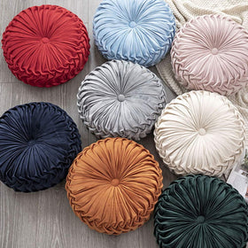Teieas beige round pillow adds cozy velvet texture to couch or bed.