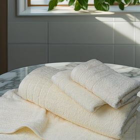 Tens Towels on a bathroom rack highlight coordinated cream tones.