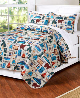 The Lakeside Collection campsite quilt pattern close-up highlighting tents and campfire colors for cozy cabin decor.