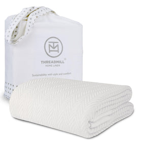 Threadmill luxury cotton blanket in king size, tusk white drapes softly on the bed.