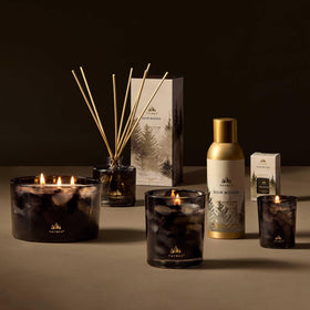 Thymes Noir Woods mist bottle on table, quick scent lift for any room.