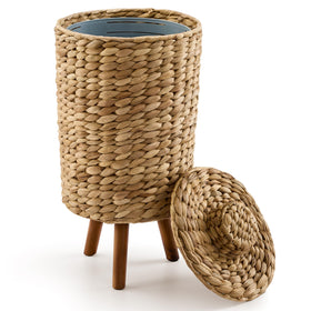Tidita wicker trash can with lid and wooden legs discreetly organizes bathroom waste.