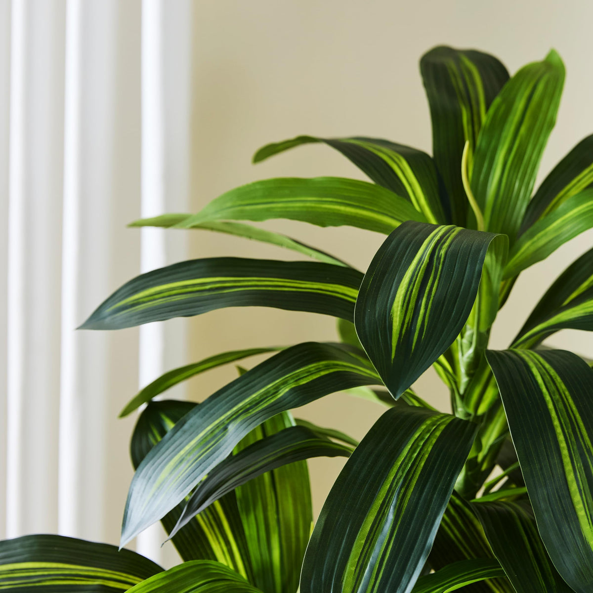 TNGGNT tall faux tree silhouette fills empty corners with elegant greenery.