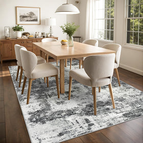 Tosuoka 8x10 abstract rug dining room arrangement under table.