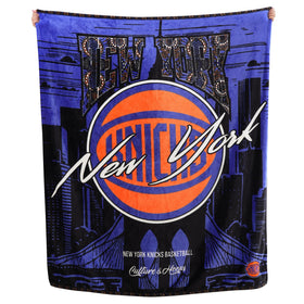 Two Hype Knicks throw blanket draped on sofa for cozy game-day warmth.