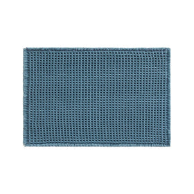 TYUU waffle bath mat denim blue stacked for storage after use.