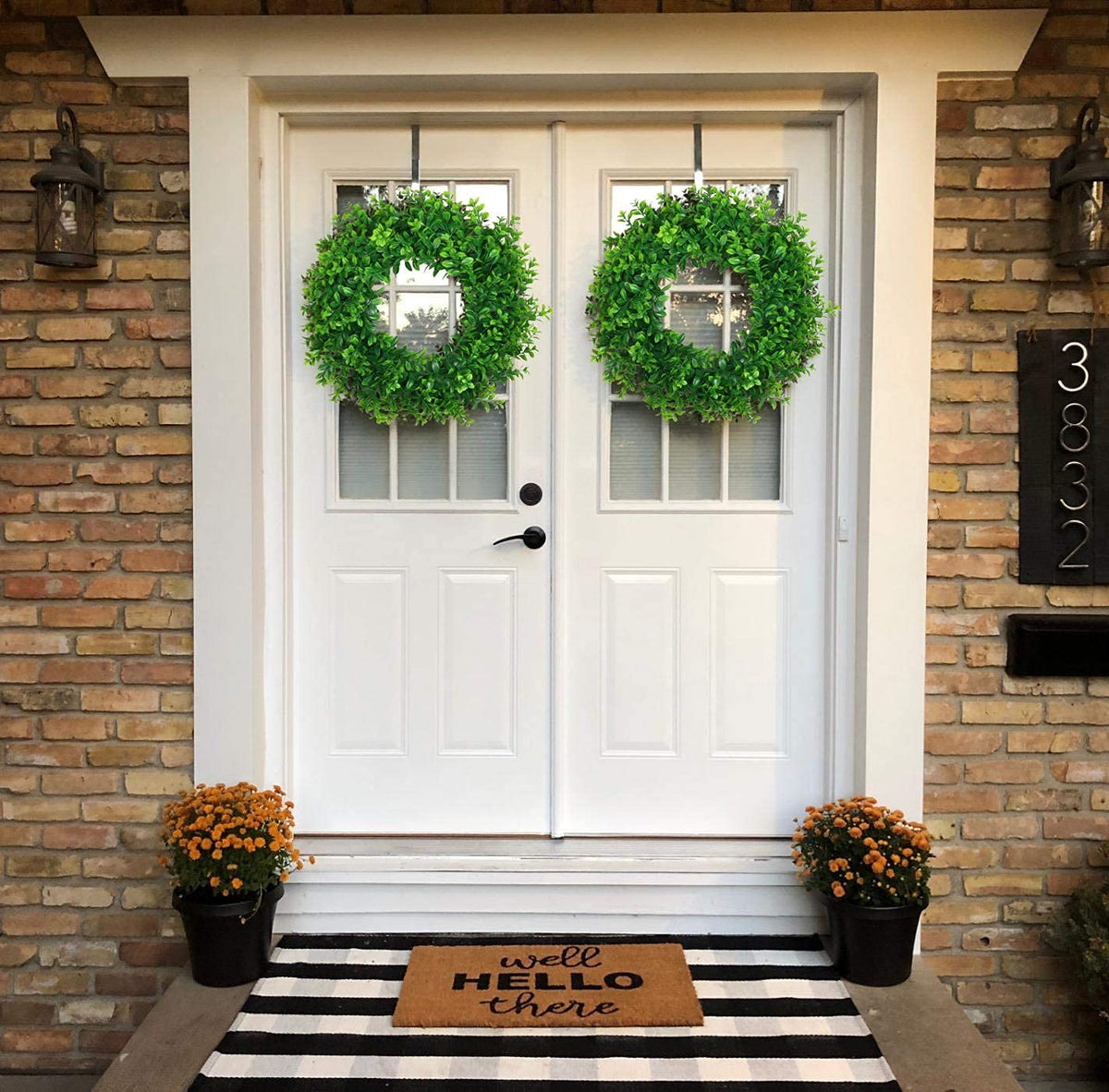 U'Artlines green wreath creates welcoming ambiance on front doors.