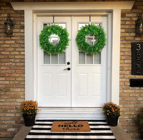 U'Artlines green wreath creates welcoming ambiance on front doors.