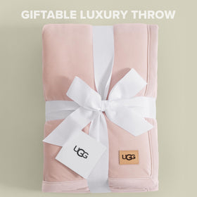 UGG Bliss Throw Blanket on bed adds soft texture and warmth.