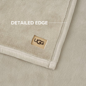 Ivory Shoreline Coco blanket displayed on bed adds luxurious texture.