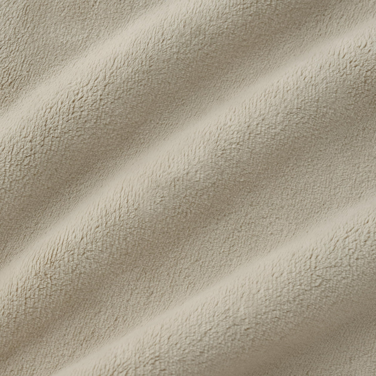 Decor-friendly Coco fleece blanket in ivory enhances living room ambience.