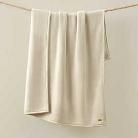 Unfolded Coco blanket on couch invites warmth during chilly nights.