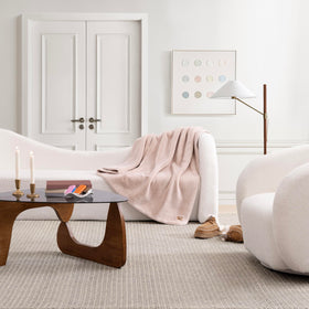 UGG Whitecap throw draped on a chair enhances modern bedroom decor.