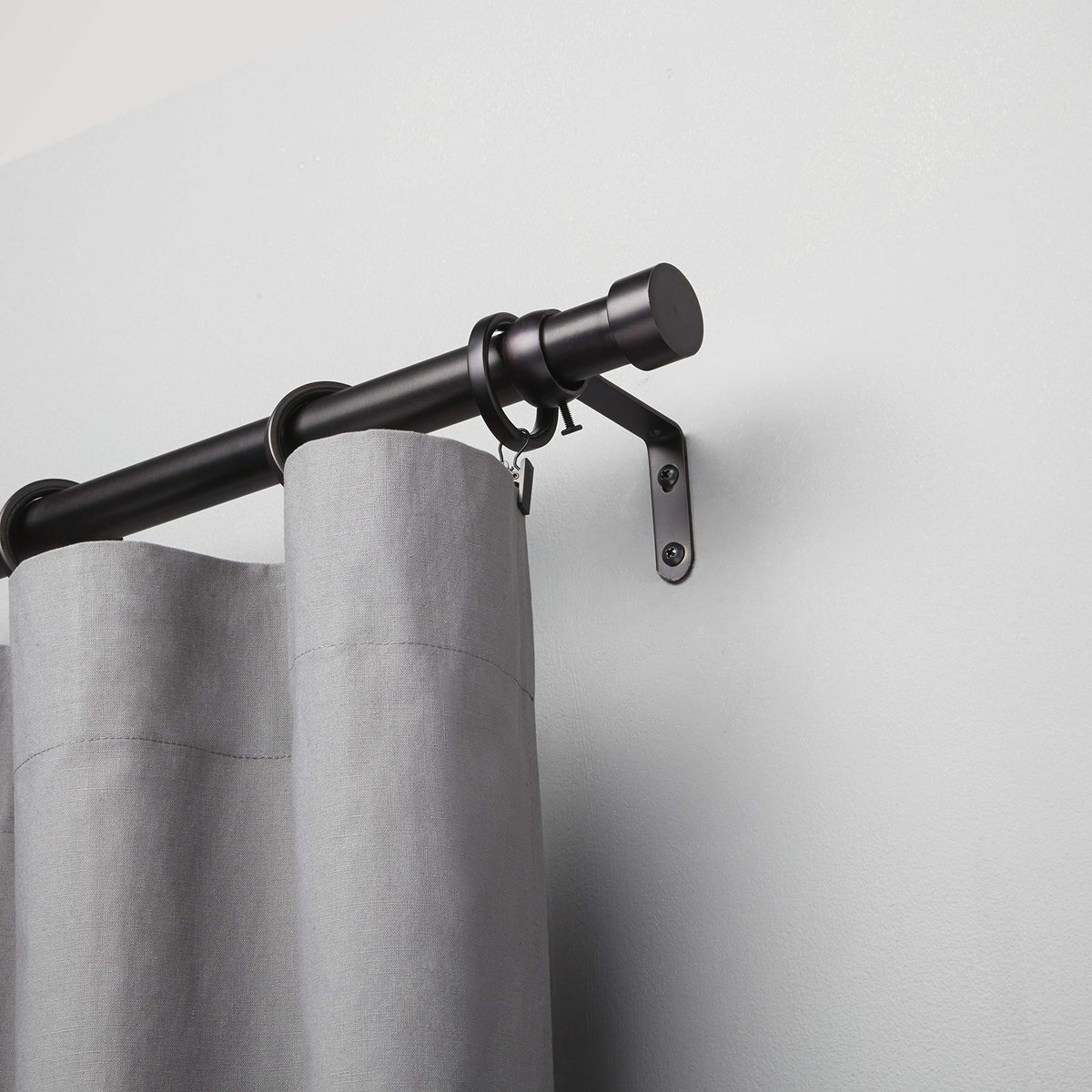 Bedroom setup featuring Umbra Cappa for light to medium drapes