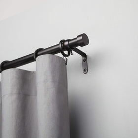 Bedroom setup featuring Umbra Cappa for light to medium drapes