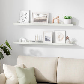 Upsimples living room setup with white floating shelves displaying decor.