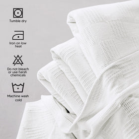 Utopia Bedding cotton blanket folded at foot of bed for warmth.