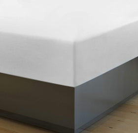 Person tucking in a neatly made bed with Utopia Bedding fitted sheet