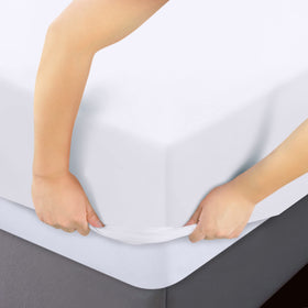 Sheet on bed highlighting all-around elastic for snug edges