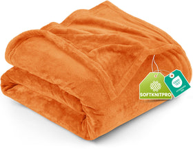 Utopia Bedding fleece blanket in burnt orange on queen bed, cozy all-season warmth.