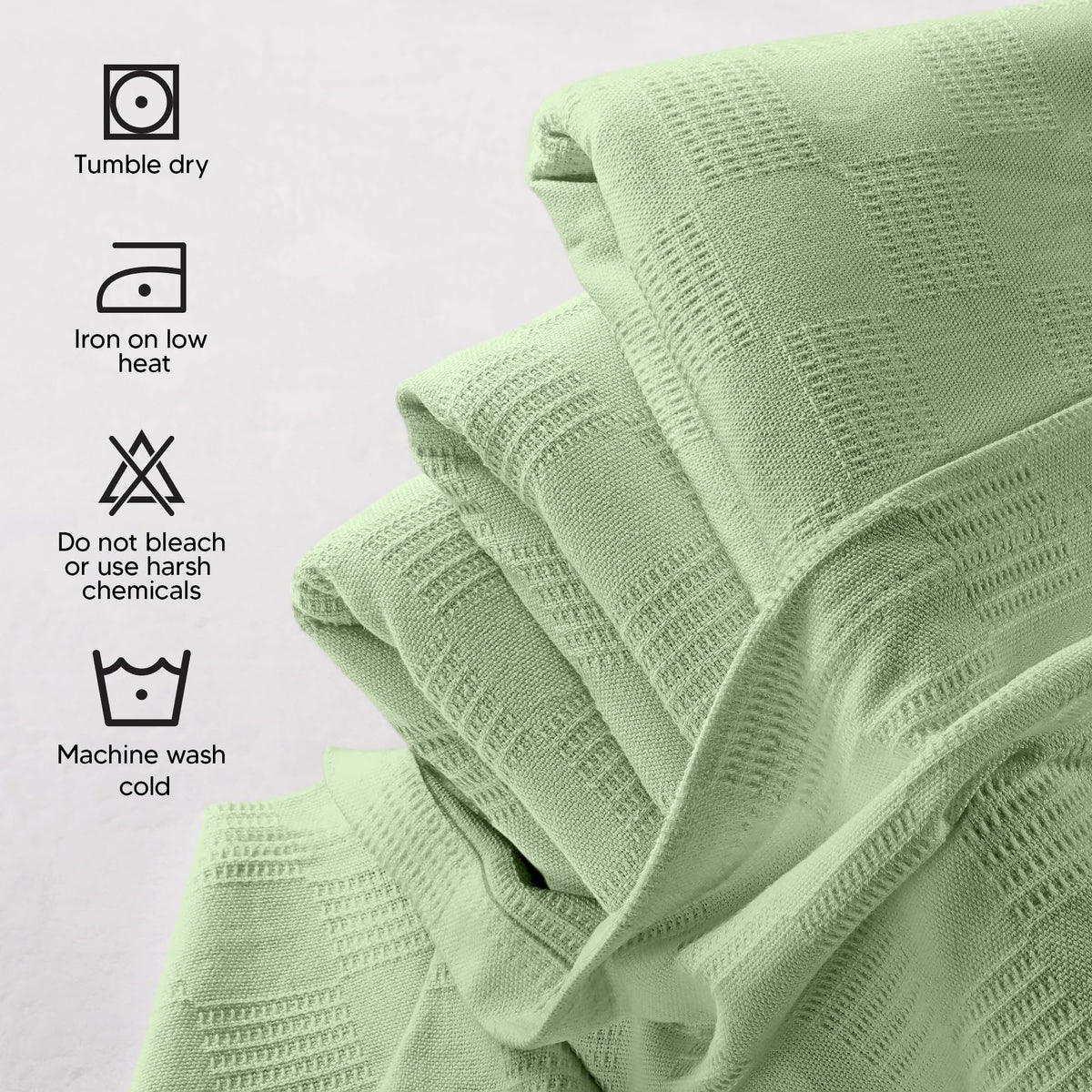 Oversized cotton blanket Sage Green from Utopia Bedding drapes over bed or couch.